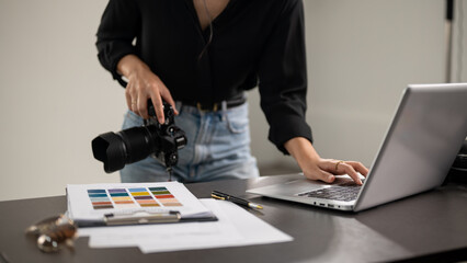 A cropped shot of a female photographer checking images on a laptop computer in a studio.