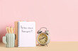 © Pixel-Shot - Notebook with French phrase, pencils and alarm clock on table against color background