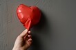 hand holding a deflated heartshaped balloon