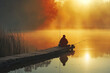 a fisherman sits on boards on the shore of a lake in the rays of the dawn sun.