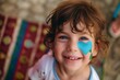 child with face paint of a blue heart on cheek smiling at camera