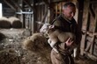 shepherd carrying newborn lamb in a barn