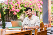 © StockImageFactory - Indian handsome student or businessman using laptop computer outdoors while sitting on table