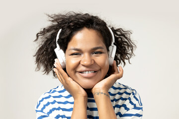 Wall Mural - Young African American woman listening to music in headphones