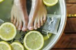 feet in a basin with lemon slices and green tea bags