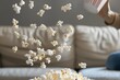 person tossing popcorn in air while lying on sofa