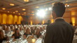 Back view of a male businessman in business attire giving a speech while holding a microphone on the stage of an indoor event banquet hall where many people are seated. Out of focus. Generative AI