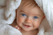 portrait of a cute adorable baby with towel, blue eyes baby, smiling, happy