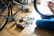 Young man repairing a bicycle at home. Mechanic serviceman repairman installing assembling or adjusting bicycle gear on wheel in workshop.