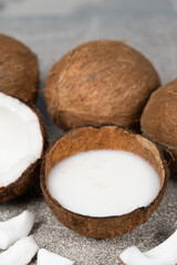 Wall Mural - Coconut milk in coconut shell on a grey background