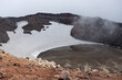View of the volcano crater. Mountain landscape. Snow and lake in a volcanic crater. Travel and hiking on the Kamchatka Peninsula. Nature of the Russian Far East. Gorely volcano, Kamchatka Krai, Russia