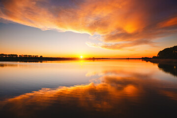 Wall Mural - Attractive view of the sunset over the calm surface of the water.