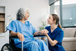© Nuttapong punna - Nurse helping elderly woman walk in the room, holding his hand, supporting. Treatment and rehabilitation after injury in assisted living facility, senior care .