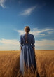 Beauty historical Early american pioneer brunette woman with long braid and blue dress outdoors. Back view. Old west, Victorian, Georgian, Edwardian. Historical romance style. Wheat field, blue sky. 