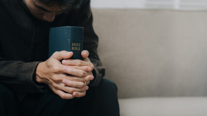 Christian man hands holding the holy bible to pray and worship God in the sunday morning.spirituality, religion,believe.Christian life.Studying the word of God in church.space for text.