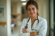 © Sebelas Studio - a doctor with arms crossed and smiling wear white blazer and stethoscope standing in a hospital