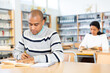© JackF - Portrait of young adult man studying in at public library