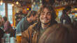 © amixstudio - Smiling young man enjoying a drink at a cozy bar with people in the background.