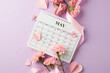 Countdown to Mother's Day: artistic flat lay with calendar and spring flowers, and paper hearts on soft purple backdrop with room for heartfelt messages