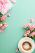 Celebrating Mother's love: Top-down vertical view of coffee cup with heart-shaped foam, gift box with pink ribbon, carnations, and paper hearts on teal background with space for greetings