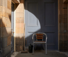 Chair In Front Of An Old Blue Wooden Door