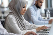 Business Meeting in office , arabian businessman & arabian Secretary wearing hijab working on laptop
