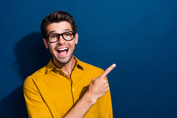 Sticker - Photo portrait of handsome young guy point excited empty space specs dressed stylish yellow outfit isolated on dark blue color background