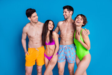 Wall Mural - Photo of cheerful funky fellows company wear swimsuits cuddling laughing isolated blue color background