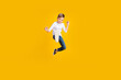 Full length photo of positive strong kid dressed white shirt jumping enjoying karate empty space isolated yellow color background