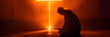 Silhouette of worshiper praying in front of cross symbol made of shining light