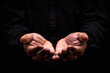 close up of male hands begging or holding something over black background