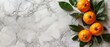   A collection of oranges atop a pristine white marble counter, accompanied by a vibrant green leafy plant