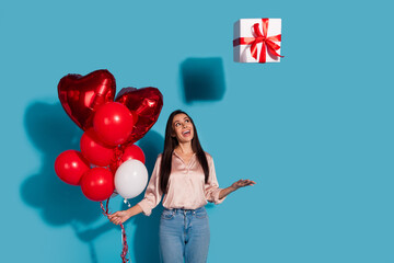 Sticker - Portrait of dreamy girl with straight hair wear silk blouse throw up present box hold balloons look up isolated on blue color background