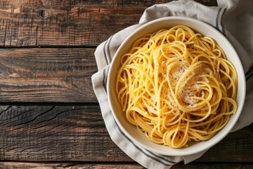 Poster - A white bowl filled with spaghetti placed off-center on a wooden table