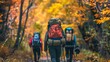A group of tourists wearing backpacks outdoors trekking on mountain in autumn fall is seen hiking on forest trail with camping backpacks. It is seen from behind the hiker woman wearing a backpack in