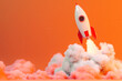 © Anastasiia Ignateva - Toy rocket launching with smoke on orange background, symbolizing startup or achievement.
