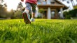 Close up of child running on green grass to new house. Child playing on garden.