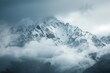 A very tall mountain covered in snow stands majestically beneath a cloudy sky