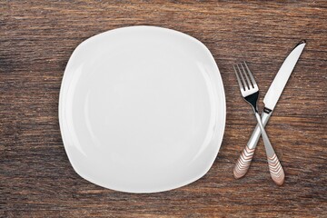 Canvas Print - Empty white plate with fork, knife, on the desk