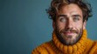   A tight shot of a bearded man in a yellow sweater and a yellow cowl encircling his neck