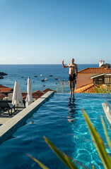 man standing in front of house in water: madeira island