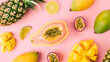 Top view creative layout with exotic summer fruits: papaya, pineapple, lime, yellow mango and passion fruit on pink background