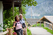 Active elderly couple on trip together, during spring day. Senior tourists visiting, exploring new places. Sightseeing, holding hands.