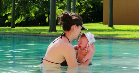 Wall Mural - Mother and infant crying newborn at the swimming pool