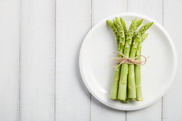 Wall Mural - Bunch of fresh asparagus on white plate