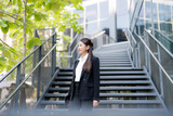 Fototapeta Natura - Confident businesswoman descending outdoor stairs