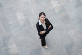 Fototapeta Natura - Successful and confident young asian businesswoman standing outdoors on a city pavement