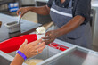 Close up view of a restaurant worker handing a cup of ice cream to a tourist. Curacao.