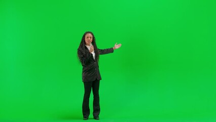 Young female reporter isolated on chroma key green screen background. Full shot african american woman tv news host talking in microphone.