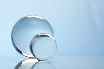 Canvas Print - Transparent glass balls on mirror surface against light background. Space for text